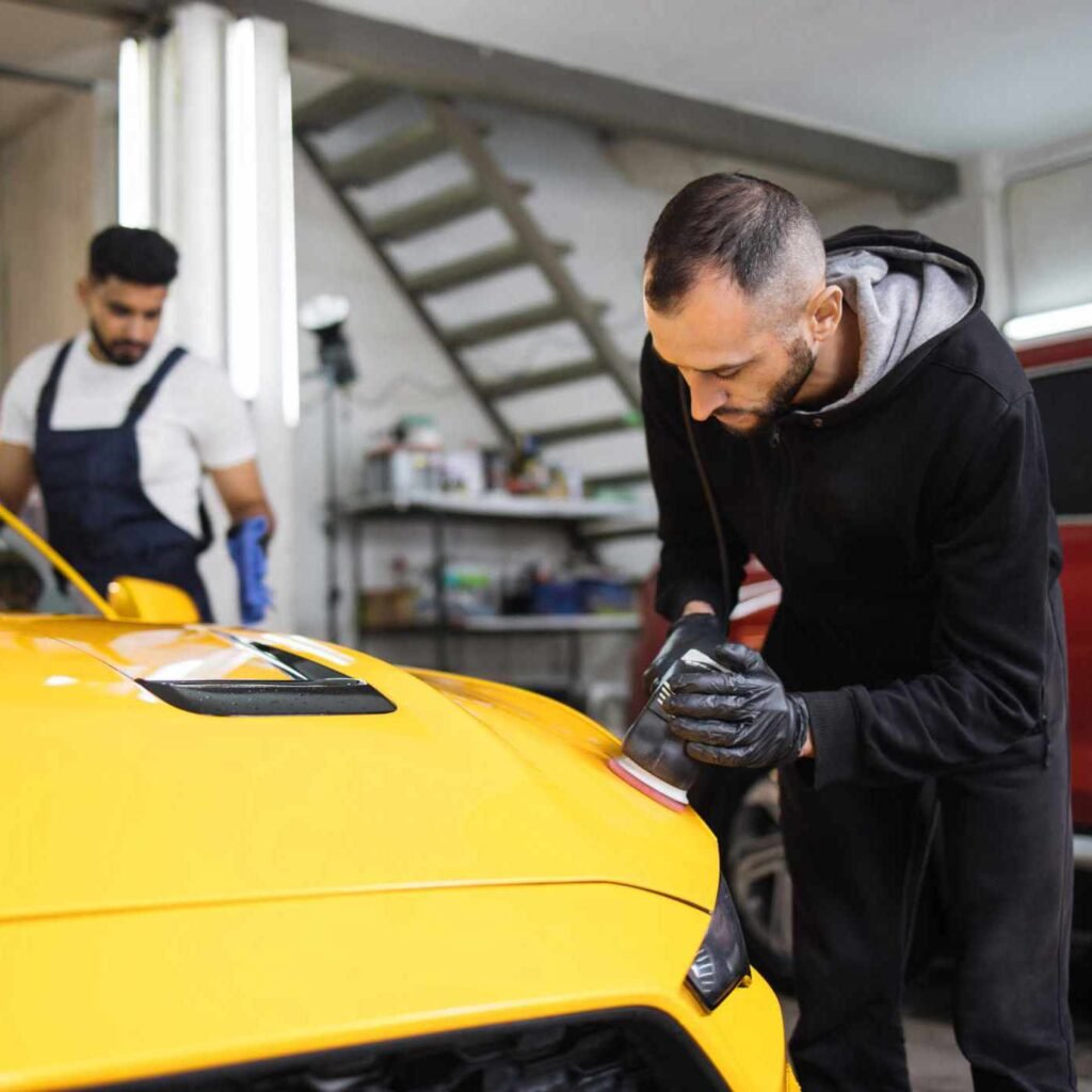 team-of-men-workers-polishing-yellow-car-body-with-B3FUCD9-1.jpg